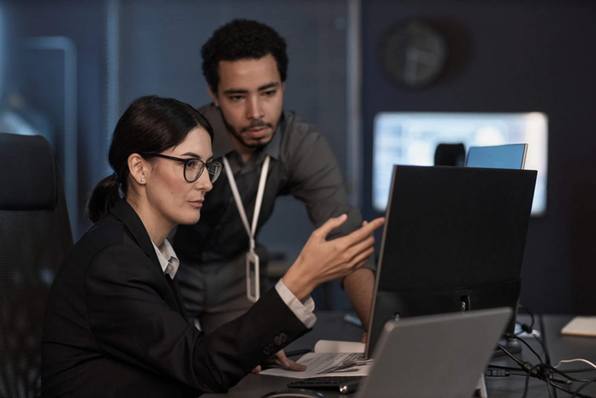 Two analysts reviewing early warning software on a shared workstation