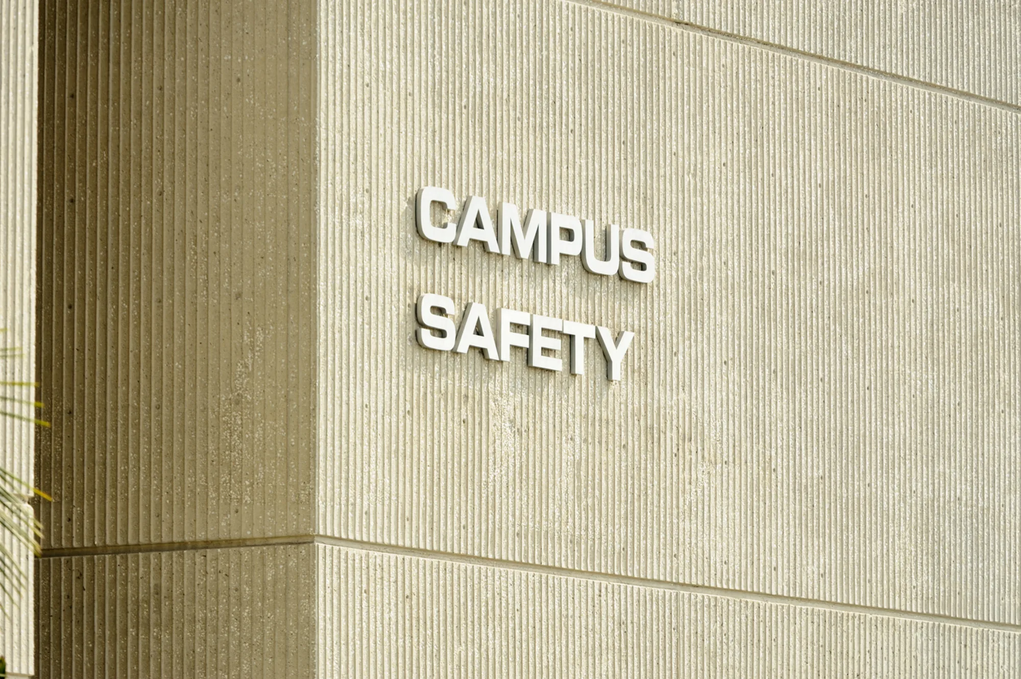 Campus safety signage mounted on an exterior concrete wall